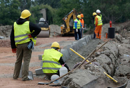 Laborers work at a road construction site.