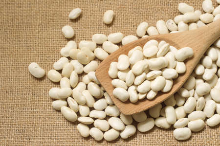 Wooden spoon with white beans