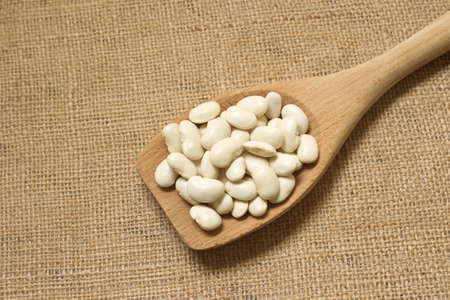 Wooden spoon with white beans