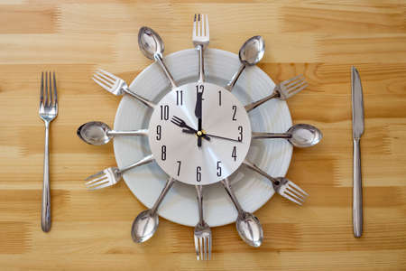 Dinner plate with clock face on wooden table
