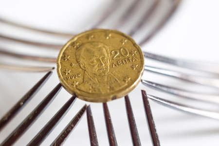 20 euro cents seen over five silver forks.