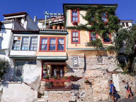 KAVALA, GREECE - JULY 6, 2017: Tourists pass along colorful houses in Kavala old town.のeditorial素材