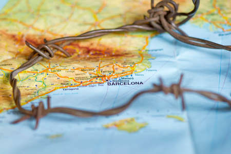 Barbed wire seen over Barcelona town map.