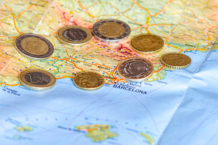 Spainish Euro coins are seen over map of Catalonia region in Spain.の写真素材