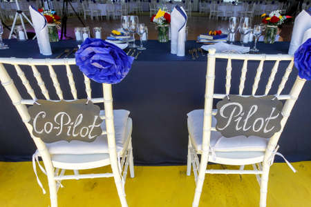 Circle dinner table served with white crockery and decorated with colorful objects.の写真素材