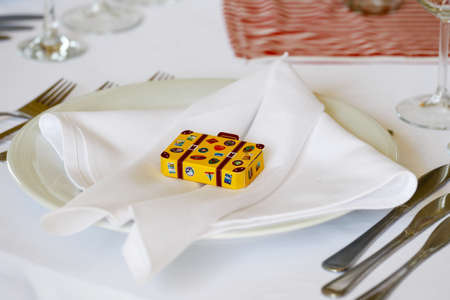 Circle dinner table served with white crockery and decorated with colorful objects.の写真素材