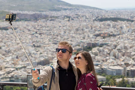 GREECE, ATHENS - 1 MAY: A young couple take a selfie with a view of Athens city, Greece, 1 May, 2019.のeditorial素材
