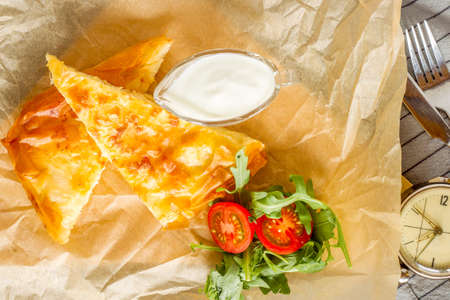 Cheese pie served with bowl of yogurt and rocket salad.の写真素材