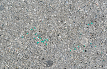 Texture of a well used asphalt. There are some oil and paint spots on it.の写真素材