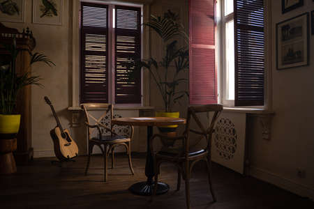 A room with a couch and table in front of a windowの写真素材
