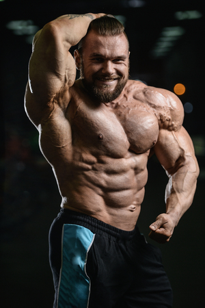 Brutal strong athletic men pumping up muscles workout bodybuilding concept background - muscular bodybuilder handsome men doing exercises in gym naked torsoの写真素材