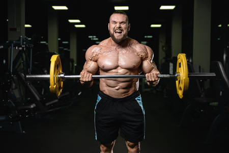 Brutal strong athletic men pumping up muscles workout bodybuilding concept background - muscular bodybuilder handsome men doing exercises in gym naked torsoの写真素材