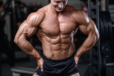 Handsome bodybuilder training in the gym sexy man lift dumbbells with topless body strong abs healthcare lifestyleの写真素材