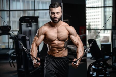 Fitness instructor handsome man in the gym gain muscle healthcare lifestyle sexy caucasian man bodybuilder work out naked body with tattooの写真素材