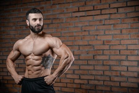 Fitness instructor handsome man in the gym gain muscle healthcare lifestyle sexy caucasian man bodybuilder work out naked body with tattooの写真素材