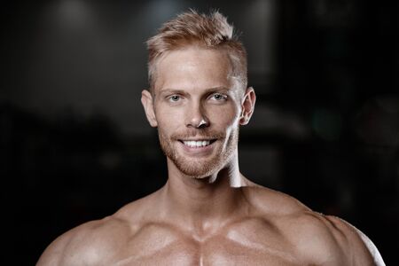 Handsome men face close up portrait in the gym Fitness strength training workout bodybuilding concept background - portrait of muscular bodybuilder handsome man doing exercises in gym naked torsoの写真素材