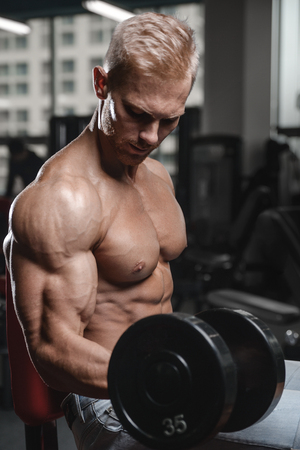 Strong and handsome athletic young man with muscles abs and biceps. Close-up of a power fitness manの写真素材
