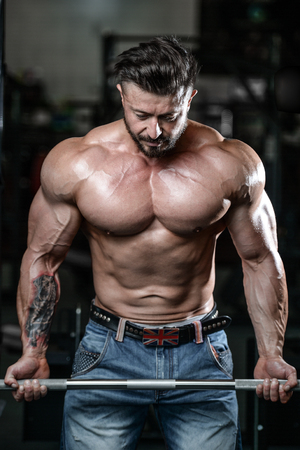 Brutal strong athletic men pumping up muscles and train in gym workout bodybuilding concept background - muscular bodybuilder handsome men doing exercises in gym naked torsoの写真素材