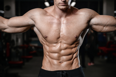 young man train in the gym healthcare lifestyle sexy caucasian man bodybuilder work out naked body torso diet in joyの写真素材