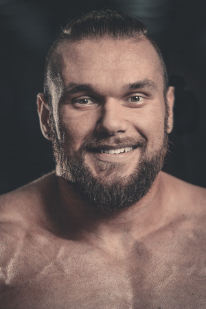 Portrait of a handsome guy on a background of gym. Face of brutal muscular sexy men in fitness gymの写真素材