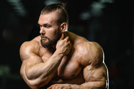 Portrait of a handsome guy on a background of gym. Face of brutal muscular sexy men in fitness gymの写真素材