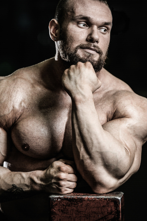 Portrait of a handsome guy on a background of gym. Face of brutal muscular sexy men in fitness gymの写真素材