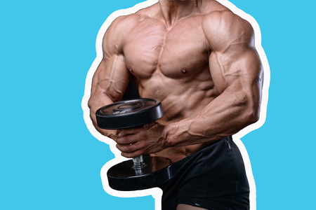 Handsome power athletic man on diet training pumping up muscles with dumbbell and barbell. Strong bodybuilder with six pack, perfect abs, shoulders, biceps, triceps and chestの写真素材