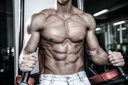 Handsome caucasian sexy fitness model in gym close up abs concept man on diet shirtless training six pack healthcare lifestyle crunchの写真素材