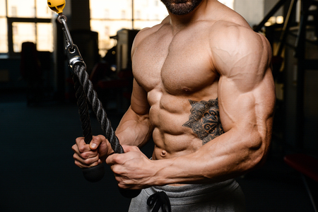 Handsome caucasian sexy fitness model in gym close up abs concept man on diet shirtless training six pack healthcare lifestyle crunchの写真素材