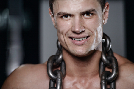 Strong and handsome athletic young man with muscles abs and biceps. Close-up of a power fitness man on dietの写真素材