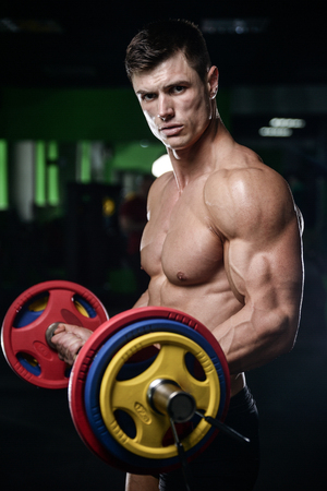 Strong and handsome athletic young man with muscles abs and biceps. Close-up of a power fitness man on dietの写真素材