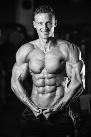 Handsome caucasian sexy fitness model in gym close up abs concept man on diet shirtless training six pack healthcare lifestyle crunchの写真素材