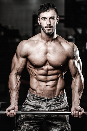 Handsome caucasian sexy fitness model in gym close up abs concept man on diet shirtless training six pack healthcare lifestyle crunchの写真素材