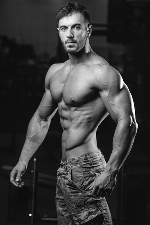 Handsome caucasian sexy fitness model in gym close up abs concept man on diet shirtless training six pack healthcare lifestyle crunchの写真素材