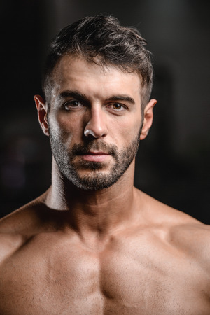 Portrait of a handsome guy on a background of gym. Face of brutal muscular sexy men in fitness gymの写真素材