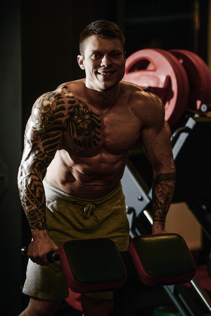 Strong and handsome athletic young tattoo man with muscles . Close-up of a power man on diet abs and biceps fitness and bodybuilding conceptの写真素材