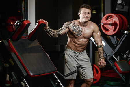 Strong and handsome athletic young tattoo man with muscles . Close-up of a power man on diet abs and biceps fitness and bodybuilding conceptの写真素材