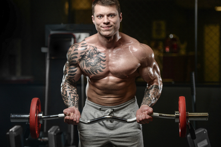 Strong and handsome athletic young tattoo man with muscles . Close-up of a power man on diet abs and biceps fitness and bodybuilding conceptの写真素材