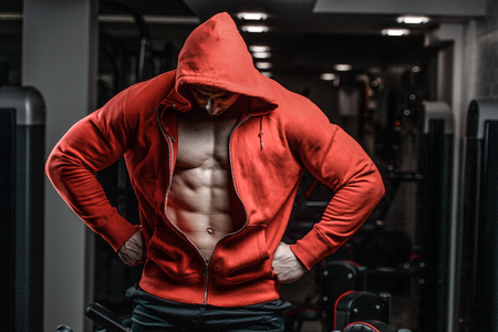 Brutal handsome Caucasian bodybuilder working out training in the gym gaining weight pumping up muscles and poses fitness and bodybuilding conceptの写真素材