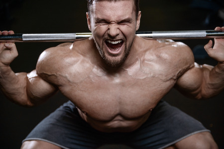 Brutal sexy strong bodybuilder athletic fitness man pumping up abs muscles workout bodybuilding concept background - muscular handsome men doing health care fitness exercises in gym naked torsoの写真素材