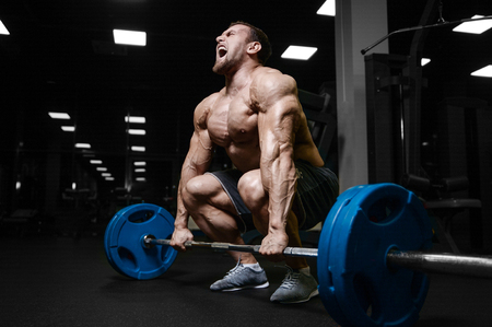 Brutal sexy strong bodybuilder athletic fitness man pumping up abs muscles workout bodybuilding concept background - muscular handsome men doing health care fitness exercises in gym naked torsoの写真素材