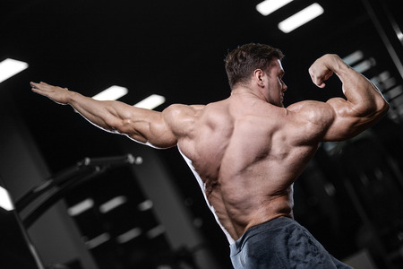 Brutal sexy strong bodybuilder athletic fitness man pumping up abs muscles workout bodybuilding concept background - muscular handsome men doing health care fitness exercises in gym naked torsoの写真素材