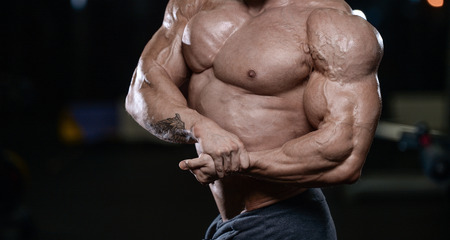 Brutal sexy strong bodybuilder athletic fitness man pumping up abs muscles workout bodybuilding concept background - muscular handsome men doing health care fitness exercises in gym naked torsoの写真素材