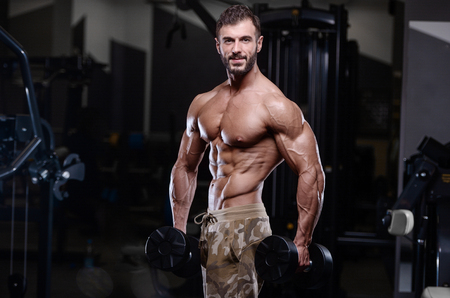 sexy strong bodybuilder athletic fitness man pumping up abs muscles workout bodybuilding concept background - muscular bodybuilder handsome men doing fitness health care exercises in gym naked torsoの写真素材