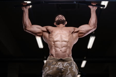 sexy strong bodybuilder athletic fitness man pumping up abs muscles workout bodybuilding concept background - muscular bodybuilder handsome men doing fitness health care exercises in gym naked torsoの写真素材