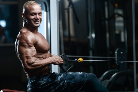 blonde brutal sexy strong bodybuilder athletic fitness man pumping up abs muscles workout...