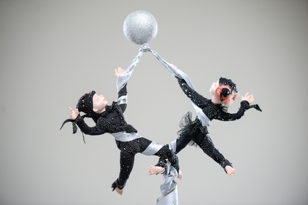 Porcelain clay pair acrobats black costume dance perforance silver ribbons circus beauty handmade handcrafted toy craft vintage decor doll gift texture conceptの写真素材