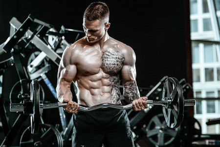 Handsome young muscular Caucasian man of model appearance working out training in the gymの写真素材