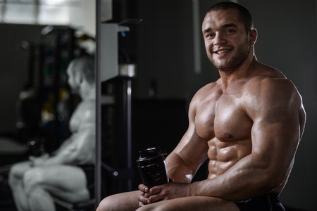 Brutal strong bodybuilder athletic fitness man pumping up abs muscles workout bodybuilding concept backgroundの写真素材