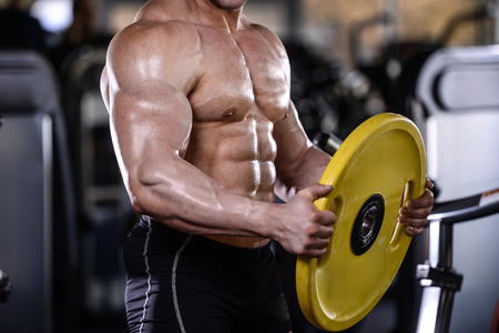 Brutal strong bodybuilder athletic fitness man pumping up abs muscles workout bodybuilding concept...